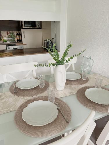 una mesa de comedor con platos y un jarrón con una planta en Strandnahe Wohnung mit Meerblick, en Sierksdorf