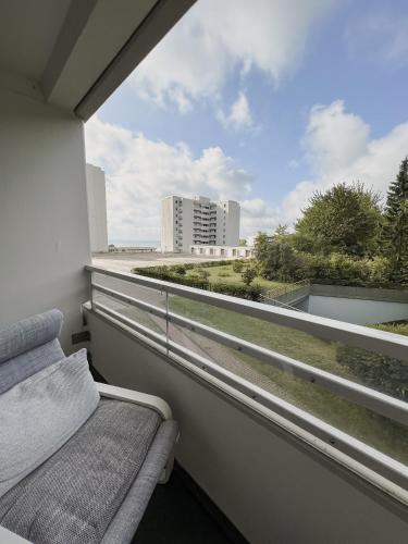 - Balcón con cama y vistas a un edificio en Strandnahe Wohnung mit Meerblick, en Sierksdorf