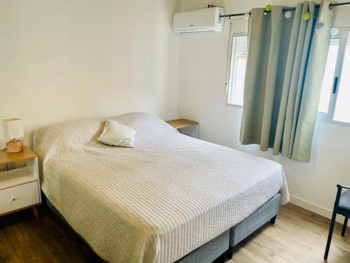 1 dormitorio con cama y ventana en Nuevo y confortable apto con parrilla, en Montevideo