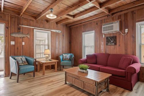 a living room with a red couch and two chairs at Beach Bum West-O Cabins in Ocean City