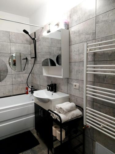 a bathroom with a sink and a mirror and a shower at Dream Arena Apartment in Bacău