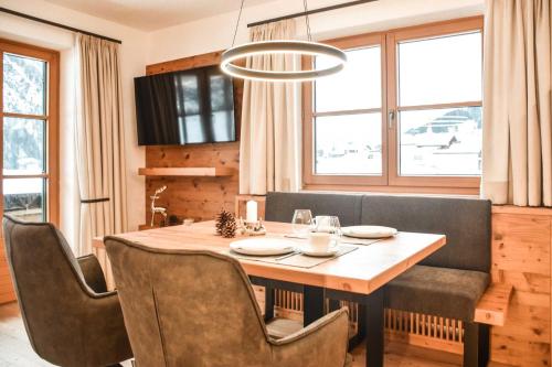 a dining room with a table and chairs and a chandelier at Landhaus Bernhard in Holzgau