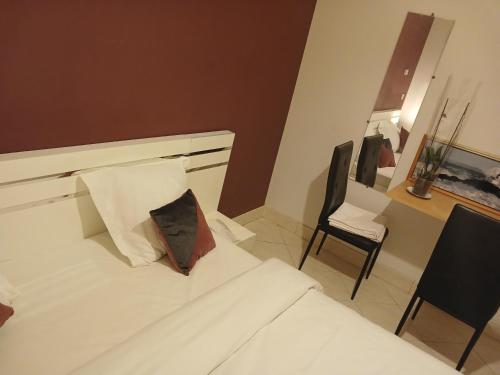 a bedroom with a white bed and a chair at PARADIS CHAMBRES D'HÔTES PROCHE PARIS - AÉROPORT CHARLES DE GAULLE AIRPORT - PARC DES EXPOSITION VILLEPINTE - DYSNAYLAND PARIS. in Tremblay En France