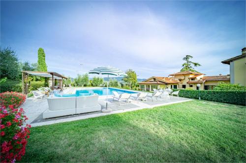 einen Garten mit Pool und Stühlen und ein Haus in der Unterkunft Borgo Spedaletto 5 - Dolcevita Holiday in Grassina