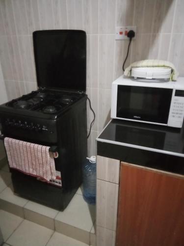 Il comprend une cuisine équipée d'une cuisinière et d'un four micro-ondes. dans l'établissement Victoria apartments, à Mtwapa
