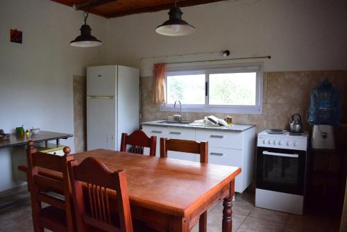 a kitchen with a wooden table and a kitchen with a stove at Casa en Cabalango in Cavalango