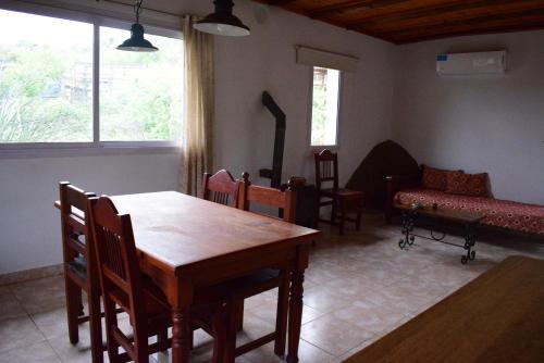 a dining room with a table and chairs and a couch at Casa en Cabalango in Cavalango