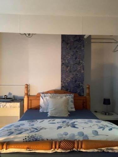 a bedroom with a bed with a blue comforter at Apartment Bradford in Bradford