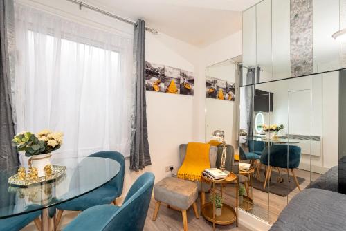 a living room with a glass table and chairs at Chic Studio Apartment, Bus 18 to Euston in 30 min. in London