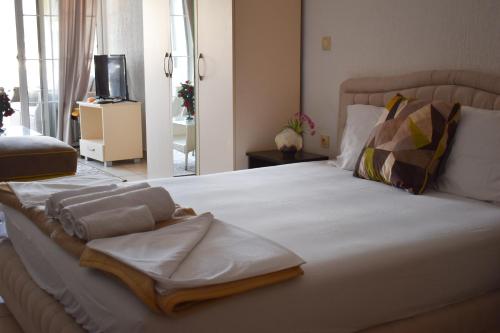 a bedroom with a large white bed with towels on it at White Hills Apartments in Budva