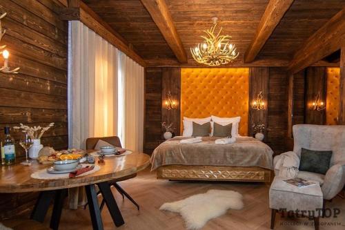 a bedroom with a bed and a table and a dining room at TatryTop Apartamenty Sobiczkowy Dwór in Zakopane