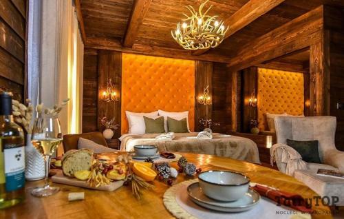 a room with a bed and a table with food on it at TatryTop Apartamenty Sobiczkowy Dwór in Zakopane