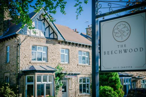 a sign in front of a house with a building at The Beechwood in Leeds