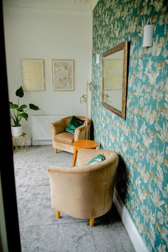 a living room with a chair and a mirror at The Beechwood in Leeds