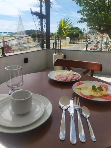 a table with plates of food and silverware on it at Ilhéus Praia Hotel in Ilhéus