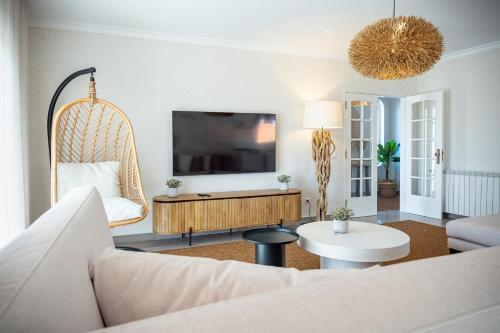 a living room with a couch and a tv at Magnolia Luxury Villa in Vieira de Leiria