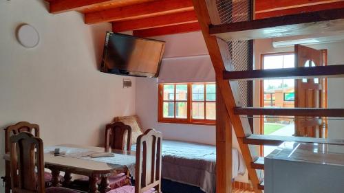 a room with a dining table and a bunk bed at Hospedaje, Departamentos J&R in Perito Moreno
