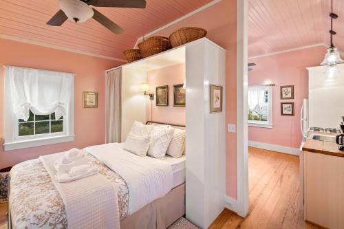 ein Schlafzimmer mit rosa Wänden und ein Bett in einem Zimmer in der Unterkunft Kent Cottage at Ivy Cottages in Crozet