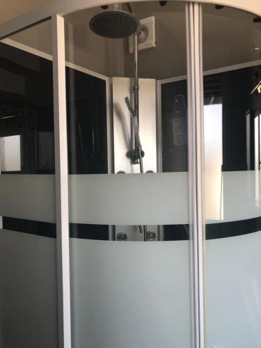 a glass door with a mirror in a room at Beauvais chambre 1 in Beauvais
