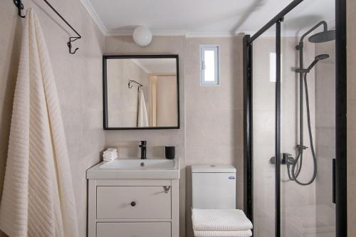 Un baño con lavabo y ducha con espejo. en Aristis apartment, en Heraclión