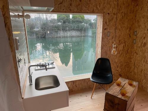 a kitchen with a sink and a window and a chair at Mugi no Oyado "Mizube" - Vacation STAY 45537v in Kuwana