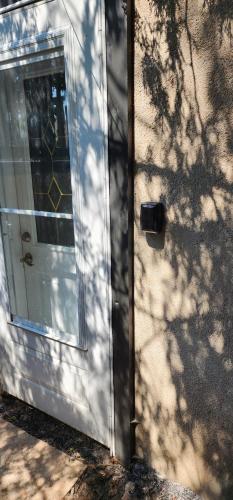 a door to a house with a shadow of a tree at Private 2-Bedroom Minutes From Trent University in Peterborough