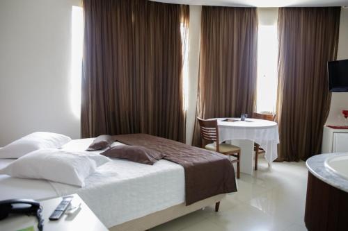 a hotel room with a bed and a bathroom at Hotel Emacite Flex in Mafra