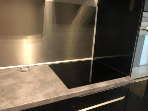 a kitchen with a counter top with black tiles at Beauvais chambre 1 in Beauvais