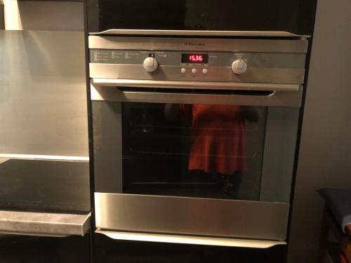 an oven with a red towel sitting inside of it at Beauvais chambre 1 in Beauvais