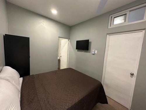 a bedroom with a bed and a television on the wall at Villa Verona in Guatemala