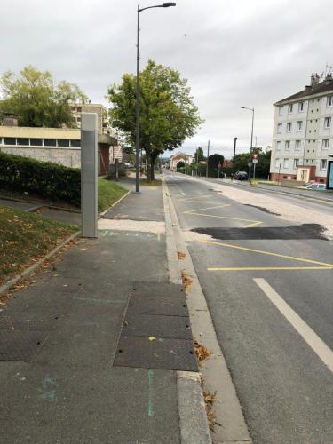 an empty street with a bus stop on the side of the road at Beauvais chambre 1 in Beauvais