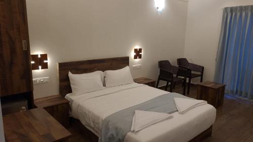 1 dormitorio con 1 cama grande y sillas en Preethys Holiday Home, en Munnar