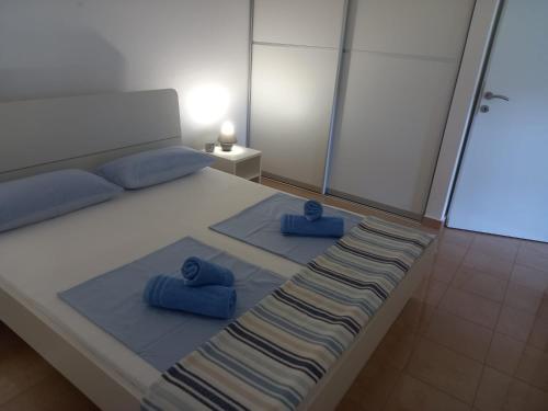 a bedroom with a bed with two blue pillows on it at Appartment IVA Kampor in Kampor