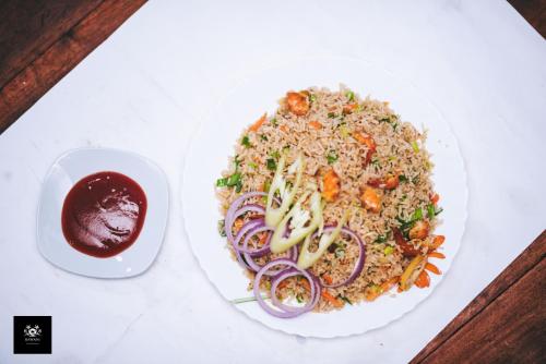 a plate of rice with vegetables and a bowl of sauce at BAWANS VILLA Holiday Home for Family or Group in Hikkaduwa