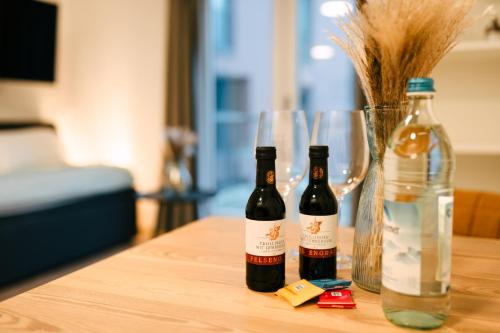 two bottles of wine on a wooden table with glasses at ZENtrahome - Zentral Business Outlet SmartTV Balkon in Metzingen