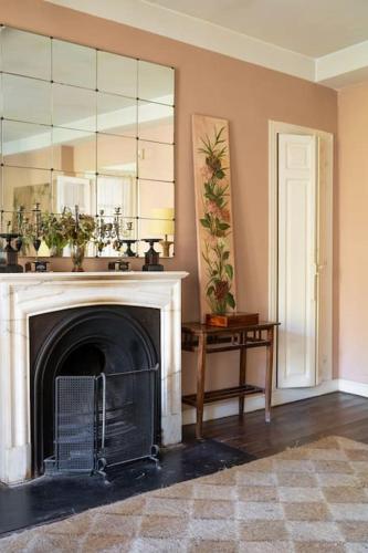 a living room with a fireplace and a mirror at Mima's House · La Casa de Mima in Comillas