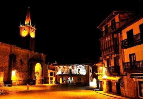 a clock tower at night with a clock tower at Mima's House · La Casa de Mima in Comillas