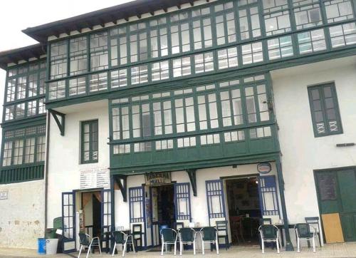 a building with tables and chairs in front of it at Mima's House · La Casa de Mima in Comillas