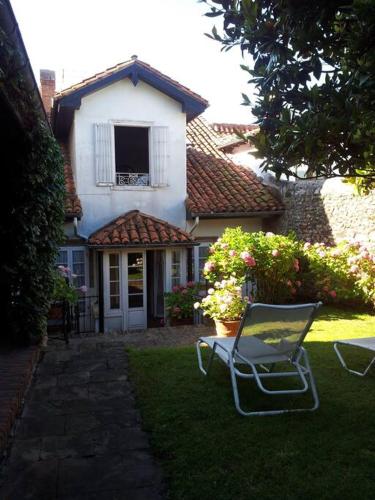 a chair sitting in the grass in front of a house at Mima's House · La Casa de Mima in Comillas