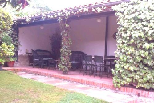 a pergola with chairs and tables on a patio at Mima's House · La Casa de Mima in Comillas