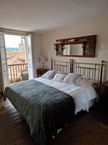 a large bed in a bedroom with a large window at Mima's House · La Casa de Mima in Comillas