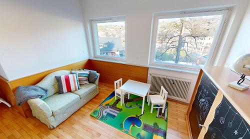 a living room with a couch and a table and two windows at Ninis - Ferienhaus im Bregenzerwald in Egg