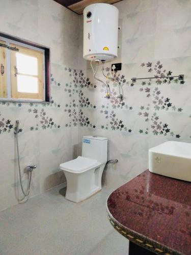 a bathroom with a toilet and a sink at Sunset View Gulmarg in Gulmarg