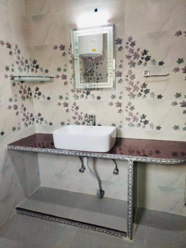 a bathroom with a sink and a mirror at Sunset View Gulmarg in Gulmarg