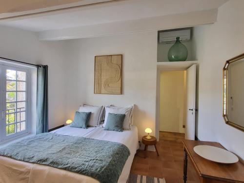 a bedroom with a large bed and a mirror at Maison Fruitier with pool at 15m from the Beach in Sainte-Maxime
