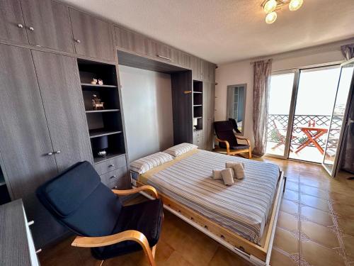 a bedroom with a bed and a blue chair at Apartamento con Vistas en Rincon de la Victoria in Cala del Moral