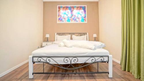 ブラショヴにあるCentral Maximus Apartmentの壁に絵画が描かれたベッドルームのベッド1台