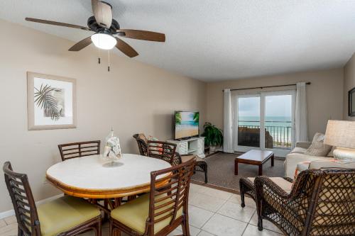 a living room with a ceiling fan and a table and chairs at Fabulous Ocean and Pool Views From Balcony & Located on No-Drive Beach in New Smyrna Beach