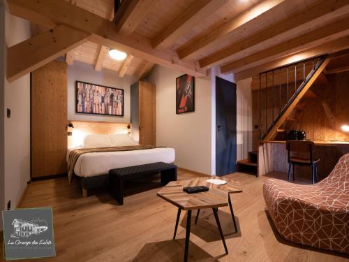 Habitación de hotel con cama y escalera en La Grange des Eulets, en Bourg-Saint-Maurice