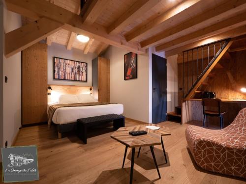 pokój hotelowy z łóżkiem i schodami w obiekcie La Grange des Eulets w mieście Bourg-Saint-Maurice